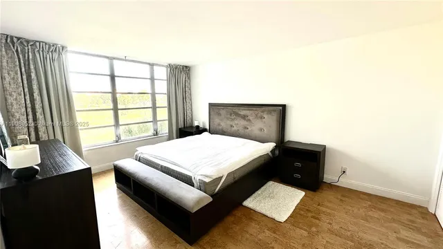 a living room with a bed furniture and a large window