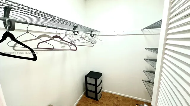 a view of walk in closet with clothes