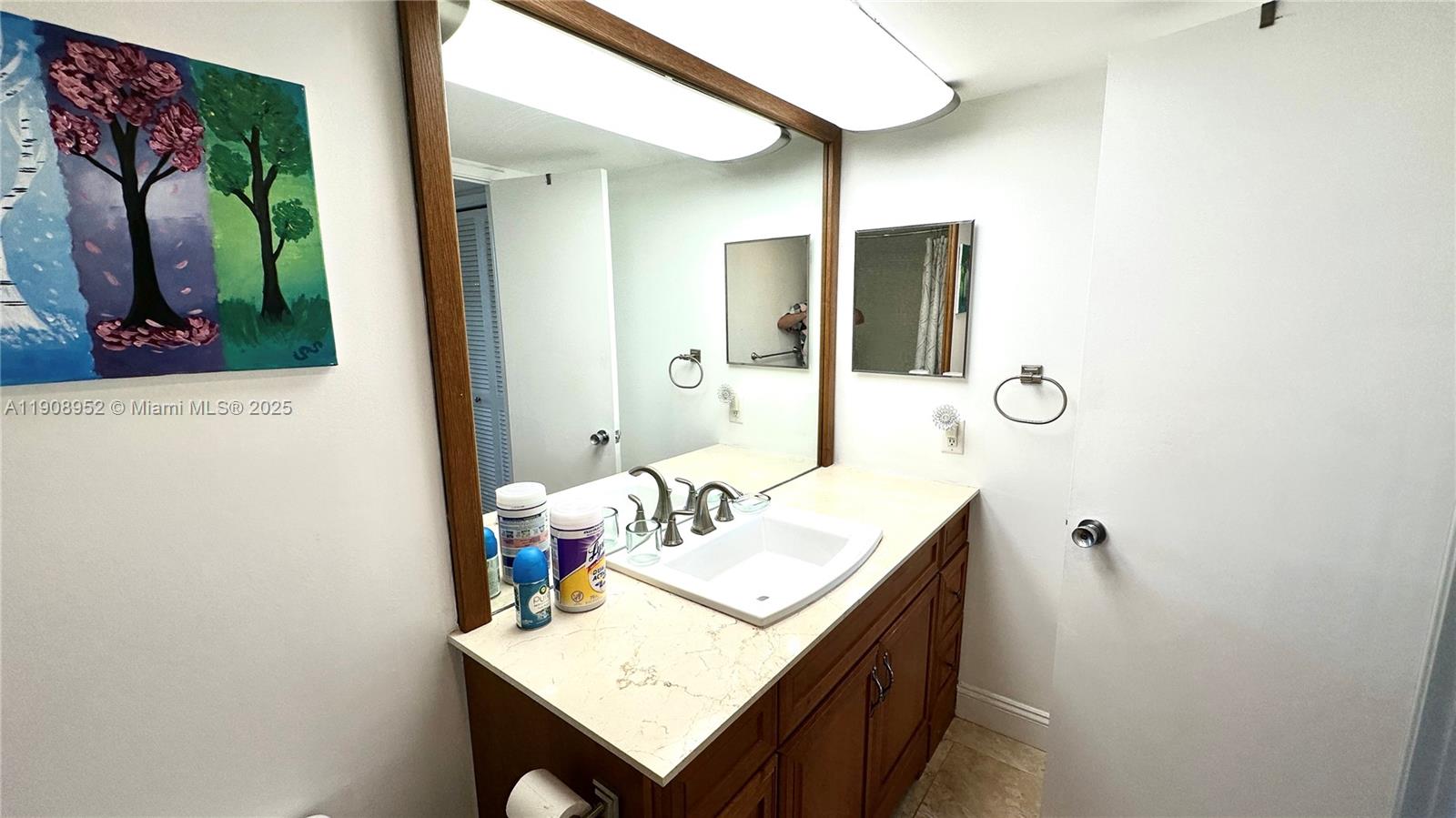 2651 South Course Drive, Unit 307 Pompano Beach, FL 33069 - Photo 22 of 33 a bathroom with a sink vanity and a mirror