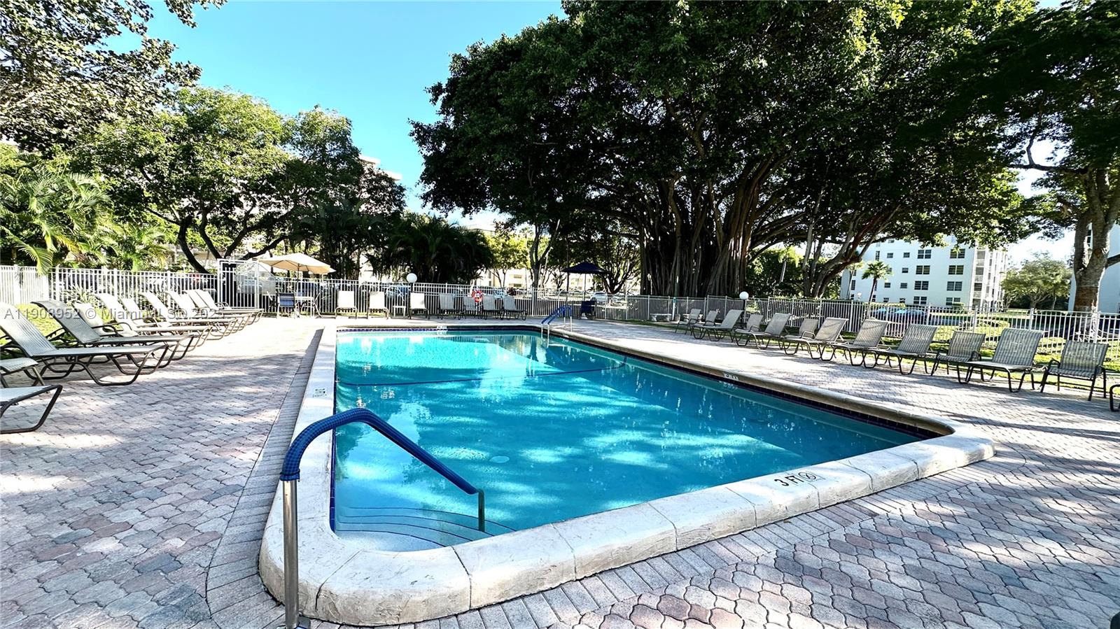 2651 South Course Drive, Unit 307 Pompano Beach, FL 33069 - Photo 28 of 33 a swimming pool with outdoor seating and yard