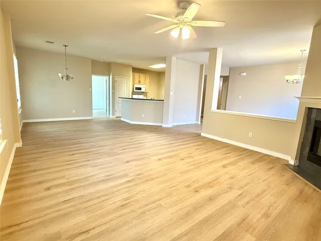 a view of an empty room and kitchen view