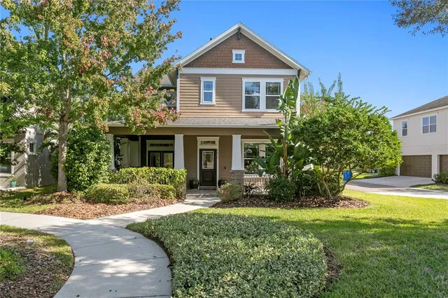 a front view of a house with a yard and potted plants