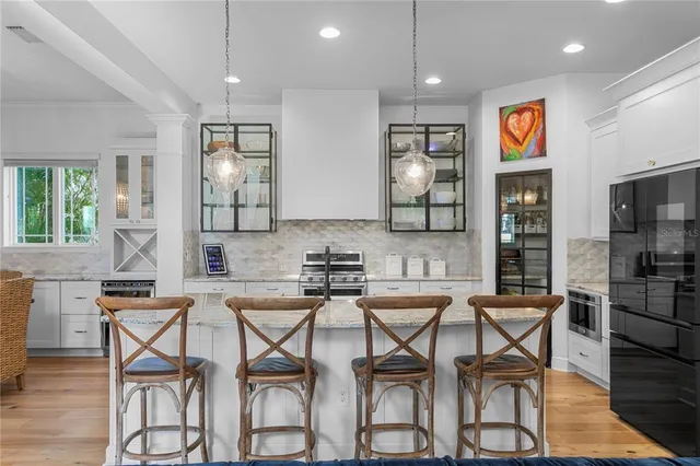 a kitchen with stainless steel appliances granite countertop a sink and a refrigerator