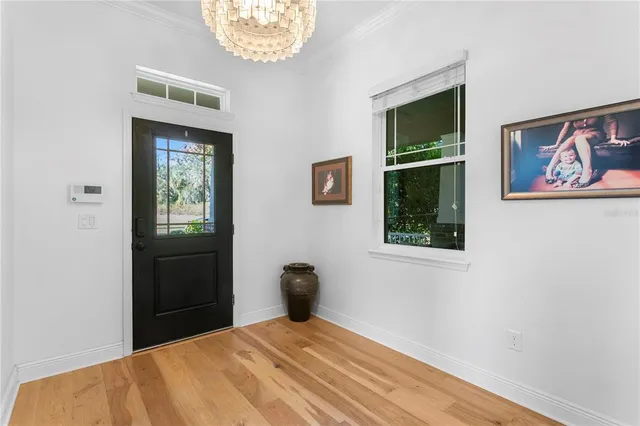 a view of a dining room with furniture a chandelier and wooden floor