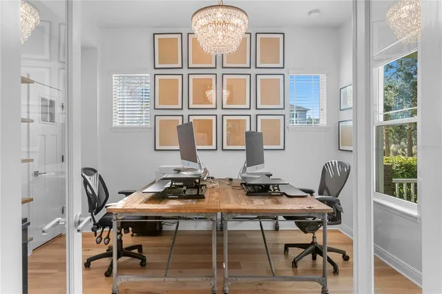 a living room with furniture a desk and chair with wooden floor
