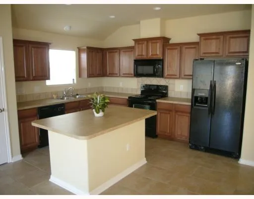 a kitchen with stainless steel appliances granite countertop a sink and a refrigerator