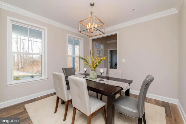 a dining room with furniture a chandelier and wooden floor
