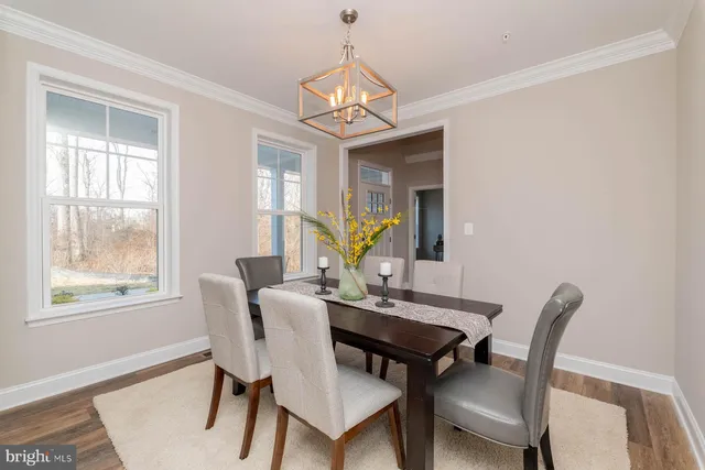 a dining room with furniture a chandelier and wooden floor