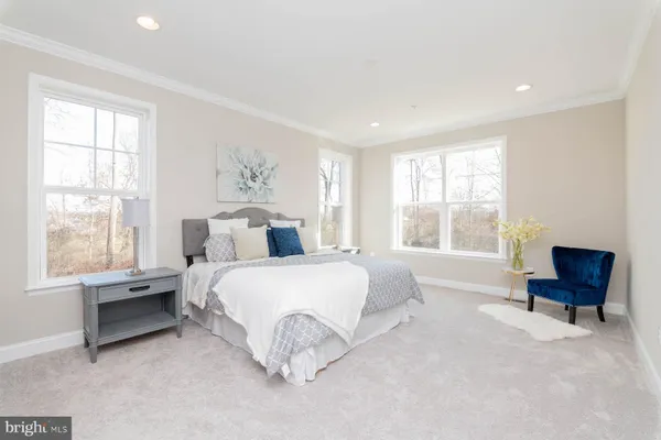 a spacious bedroom with a bed and a chair