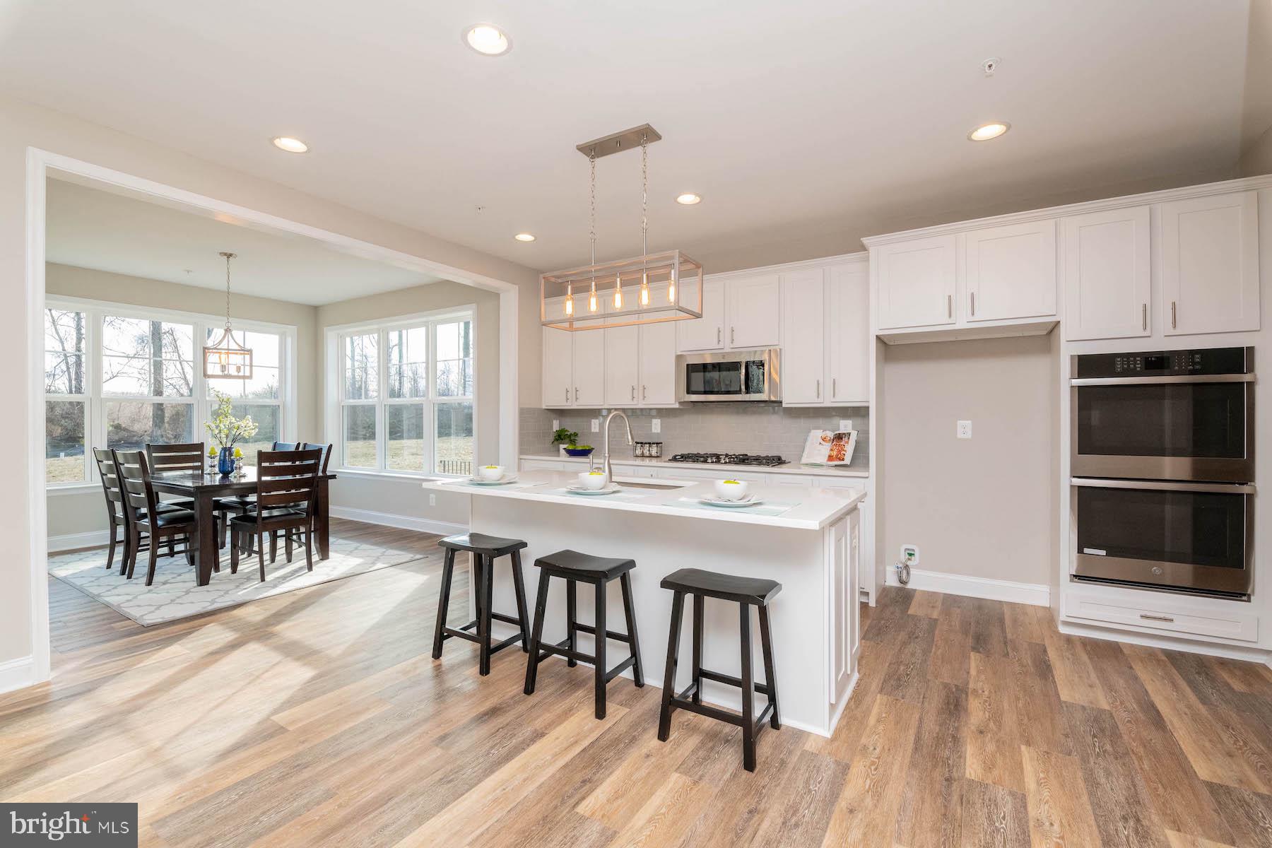 Margate York Road Parkton, MD 21120 - Photo 3 of 21 a kitchen with stainless steel appliances a dining table chairs stove and cabinets