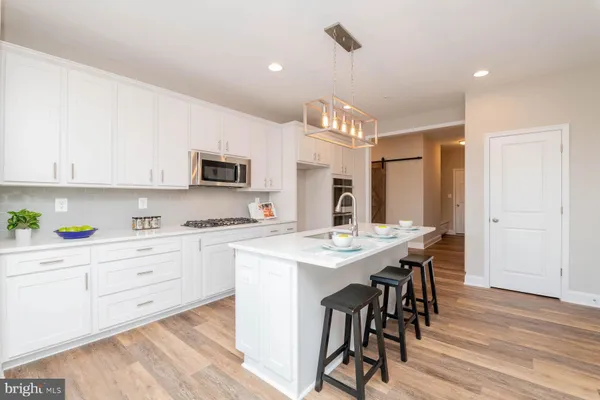 a kitchen with a table chairs refrigerator and cabinets
