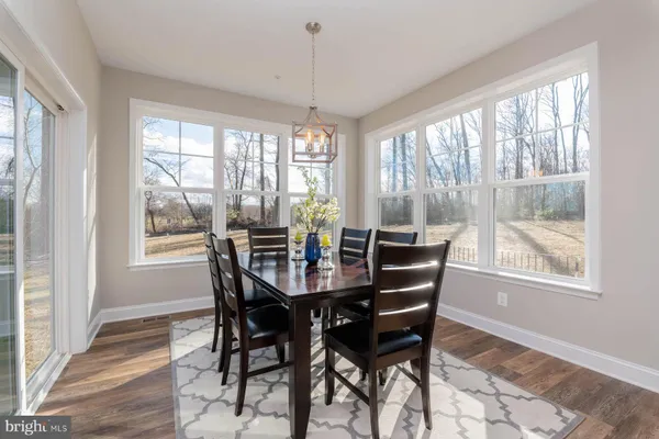 a view of a dining room with furniture large windows and wooden floor
