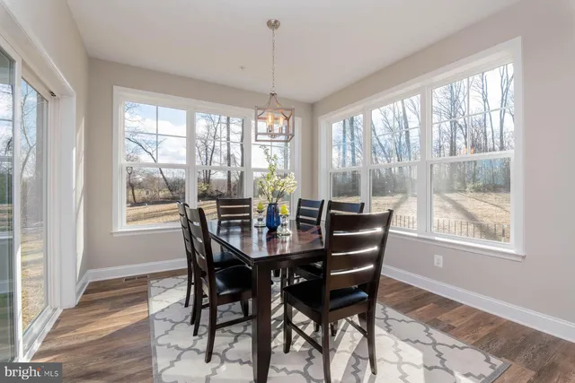 a view of a dining room with furniture large windows and wooden floor