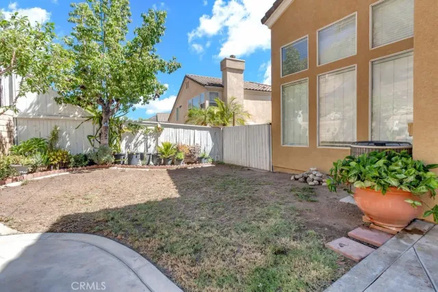 a view of a backyard with plants and a bench