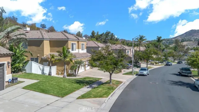 a front view of a house with a yard and potted plants