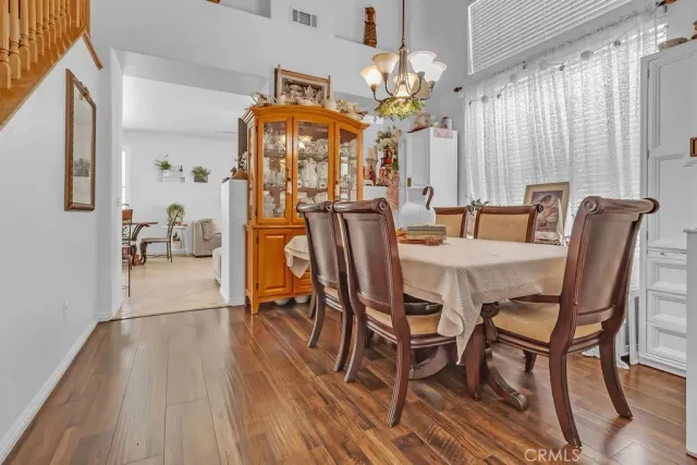 a dining room with furniture a chandelier and wooden floor