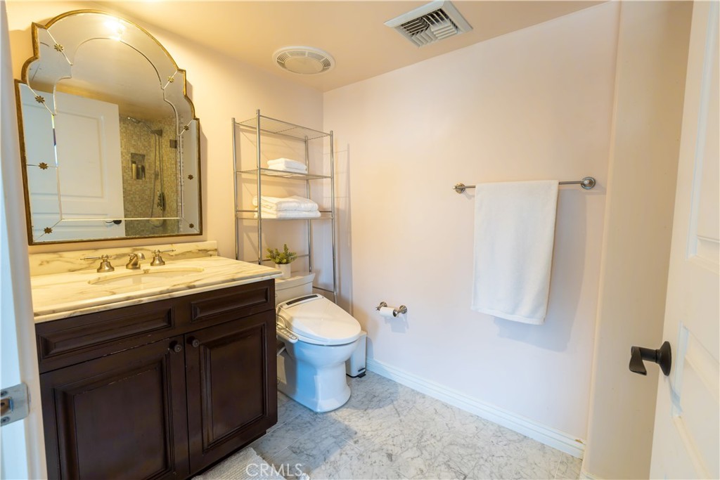10795 Wilshire Boulevard, Unit 402 Los Angeles, CA 90024 - Photo 11 of 20 a bathroom with a granite countertop sink toilet and shower