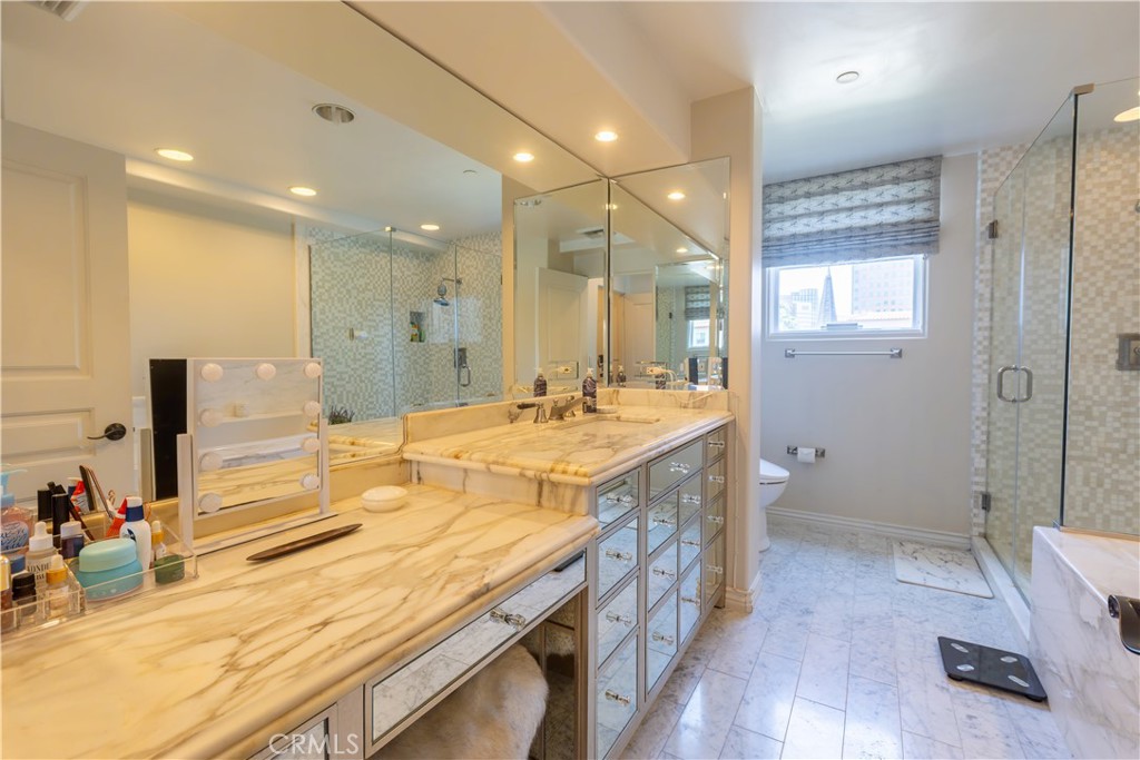 10795 Wilshire Boulevard, Unit 402 Los Angeles, CA 90024 - Photo 16 of 20 a bathroom with a tub sink and mirror