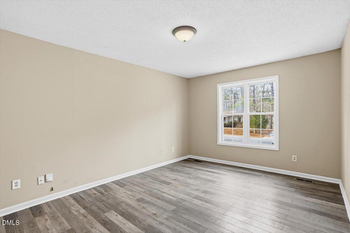 1013 Spawn Place Knightdale, NC 27545 - Photo 15 of 22 an empty room with wooden floor and windows
