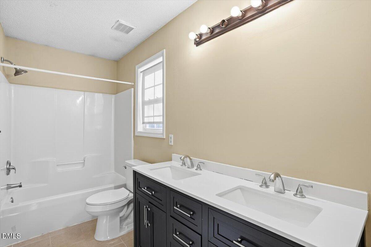 1013 Spawn Place Knightdale, NC 27545 - Photo 17 of 22 a bathroom with a double vanity sink toilet and shower