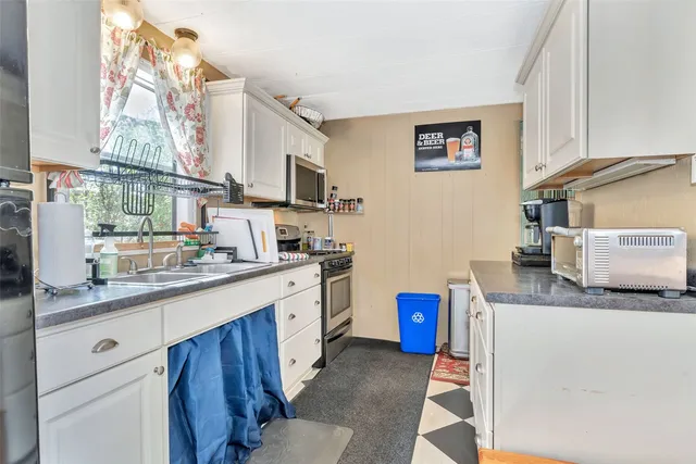 a kitchen with granite countertop a sink stove and cabinets