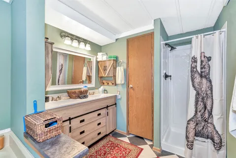 a bathroom with a double vanity sink mirror and shower