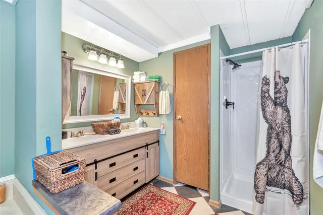 a bathroom with a double vanity sink mirror and shower