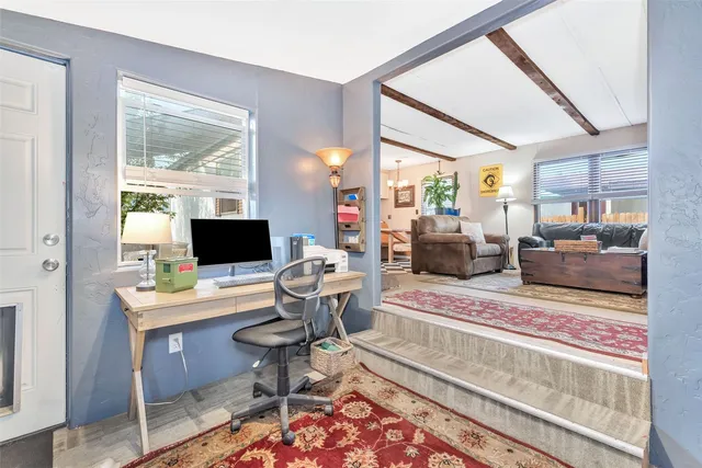 a living room with furniture a flat screen tv and a floor to ceiling window