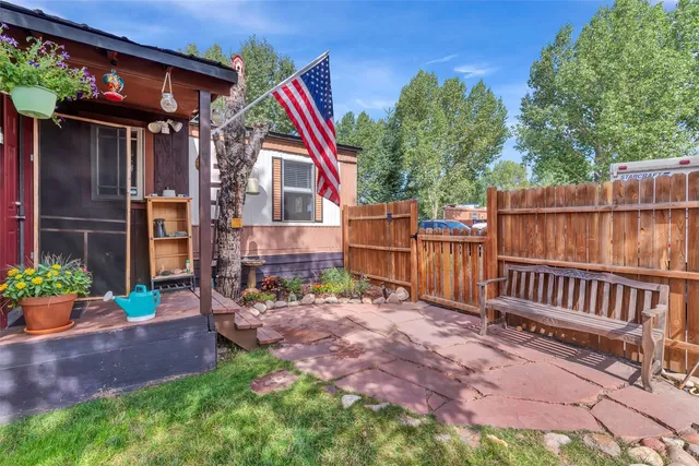 a view of house with backyard and furniture