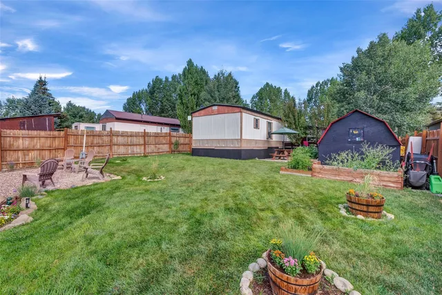 a backyard of a house with table and chairs