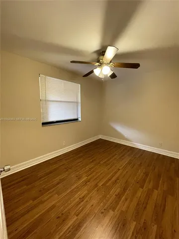 a view of a room with wooden floor and a ceiling fan