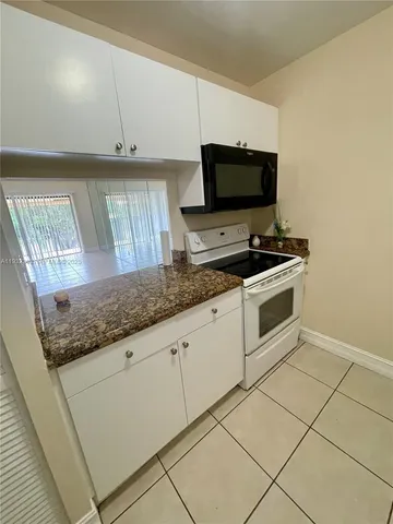 a kitchen with granite countertop a sink and a stove top oven