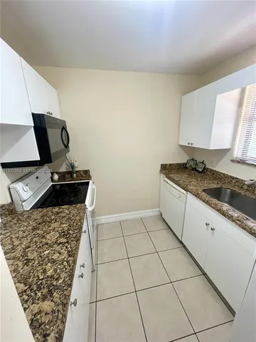 a kitchen with granite countertop a sink and a stove