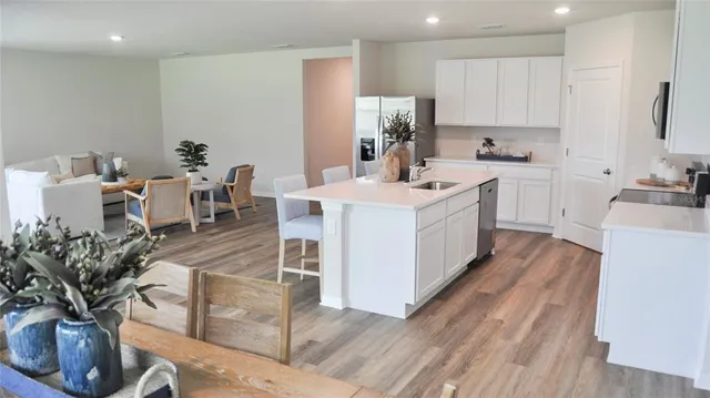 a kitchen with a table chairs refrigerator and cabinets