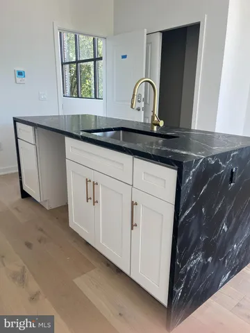 a close view of a sink a mirror and cabinets in a room