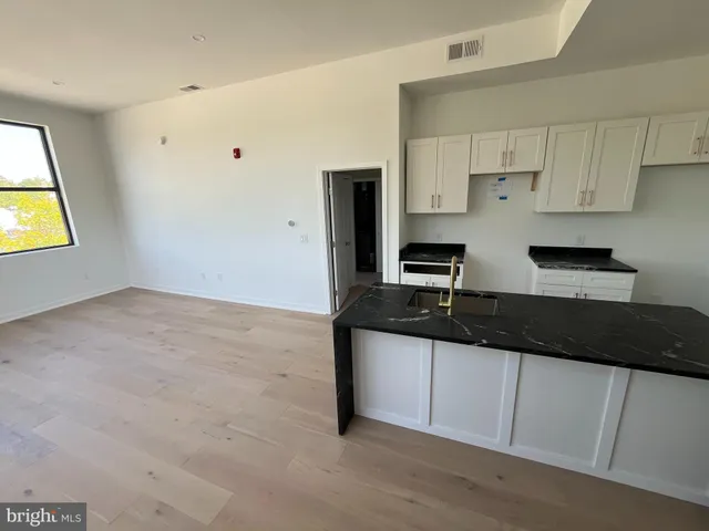 a kitchen with granite countertop a sink a stove and cabinets