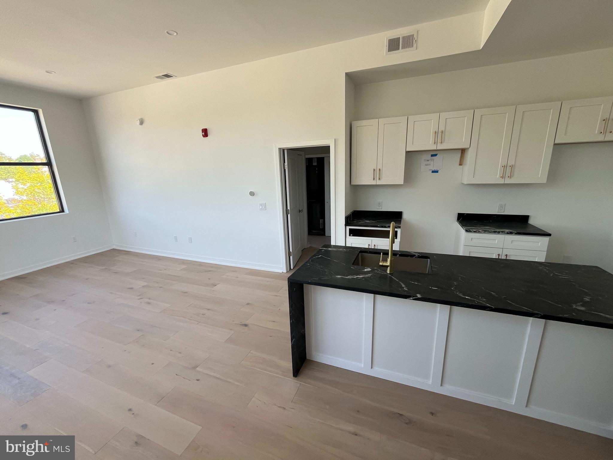 36 North Narberth Avenue, Unit 2D Narberth, PA 19072 - Photo 7 of 10 a kitchen with granite countertop a sink a stove and cabinets
