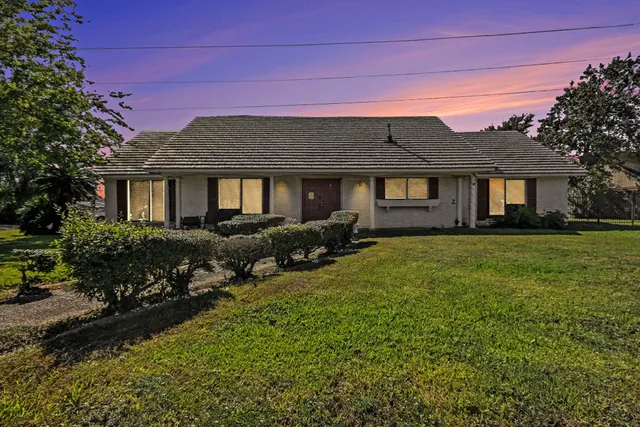 a front view of a house with a garden
