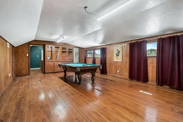 a room with pool table and windows
