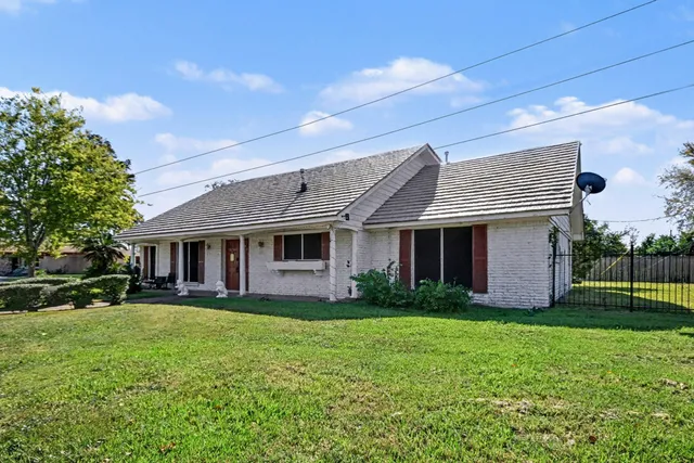 a front view of a house with a yard and trees