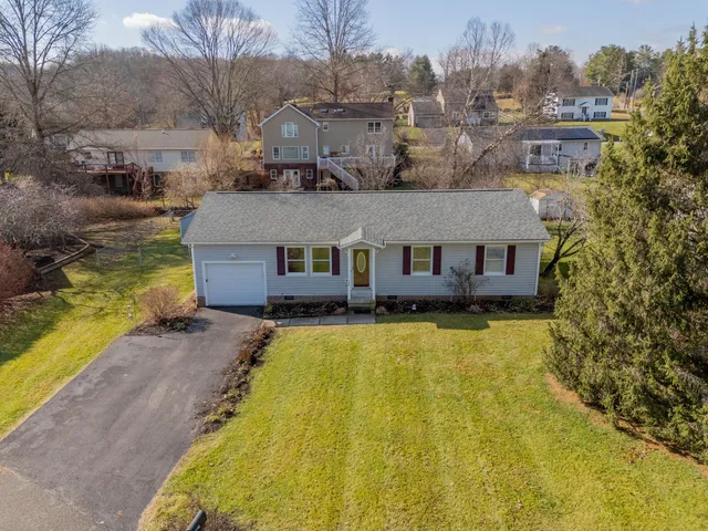 a aerial view of a house with swimming pool yard and large trees