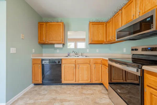 a kitchen with stainless steel appliances granite countertop a stove a sink and a microwave
