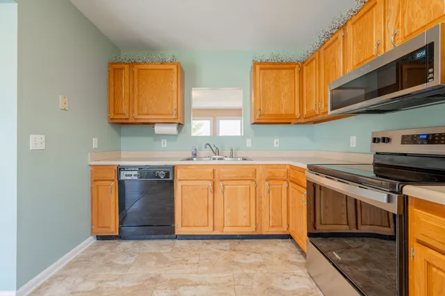 a kitchen with stainless steel appliances granite countertop a stove a sink and a microwave