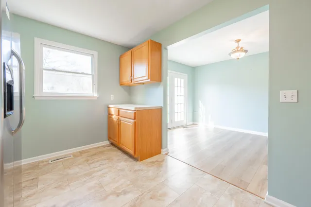 a view of a kitchen with wooden floor and a window