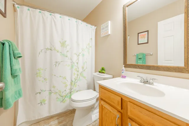 a bathroom with a sink a toilet and shower curtain
