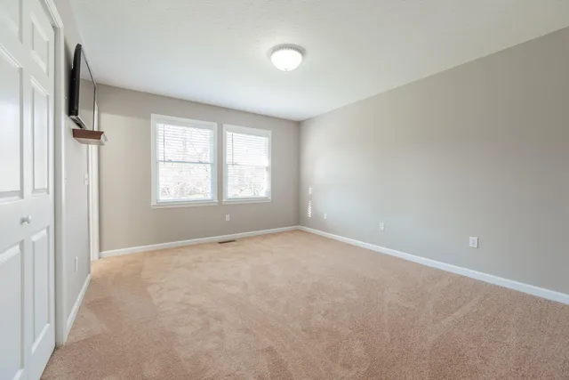 an empty room with windows and closet