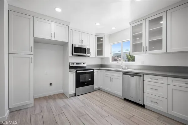 a kitchen with granite countertop white cabinets and stainless steel appliances