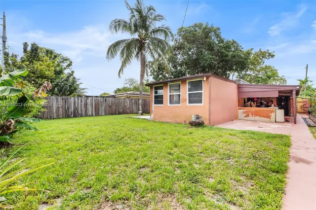 a view of a house with backyard and sitting area