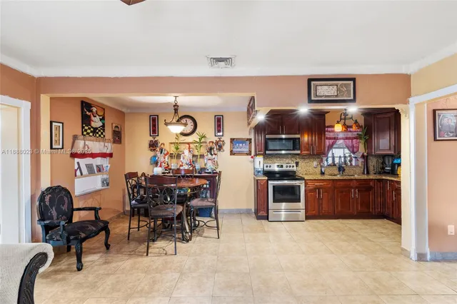 a kitchen with stainless steel appliances kitchen island granite countertop a refrigerator and chairs