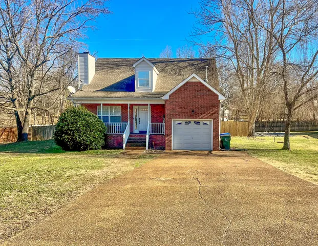 a view of a house with a yard and garage